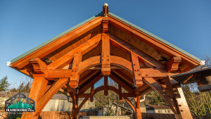 A wooden structure with an open roof and blue sky.